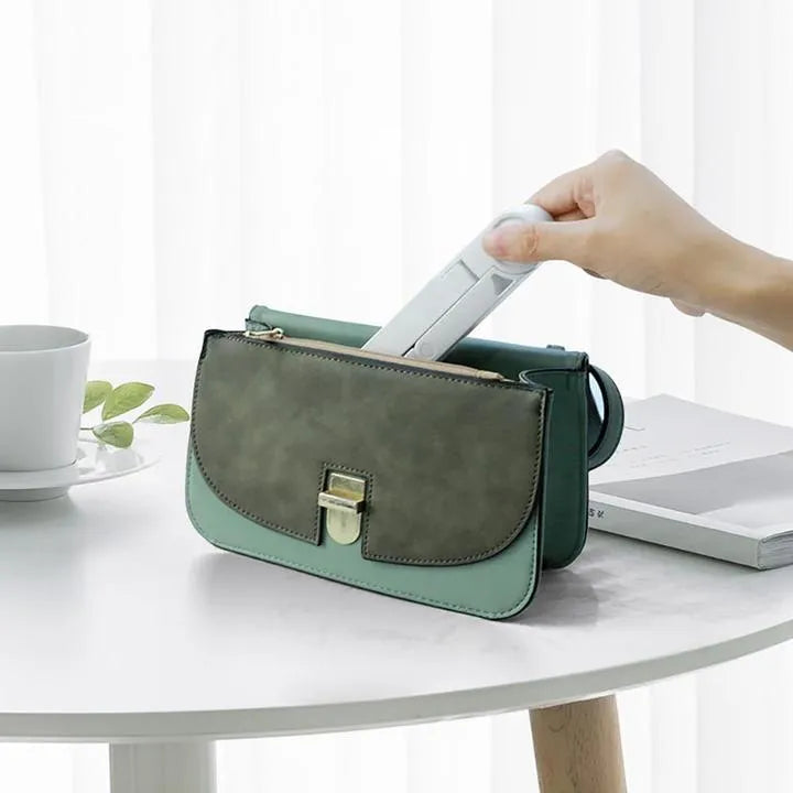 Black foldable tablet holder displaying smartphone in landscape position on desk