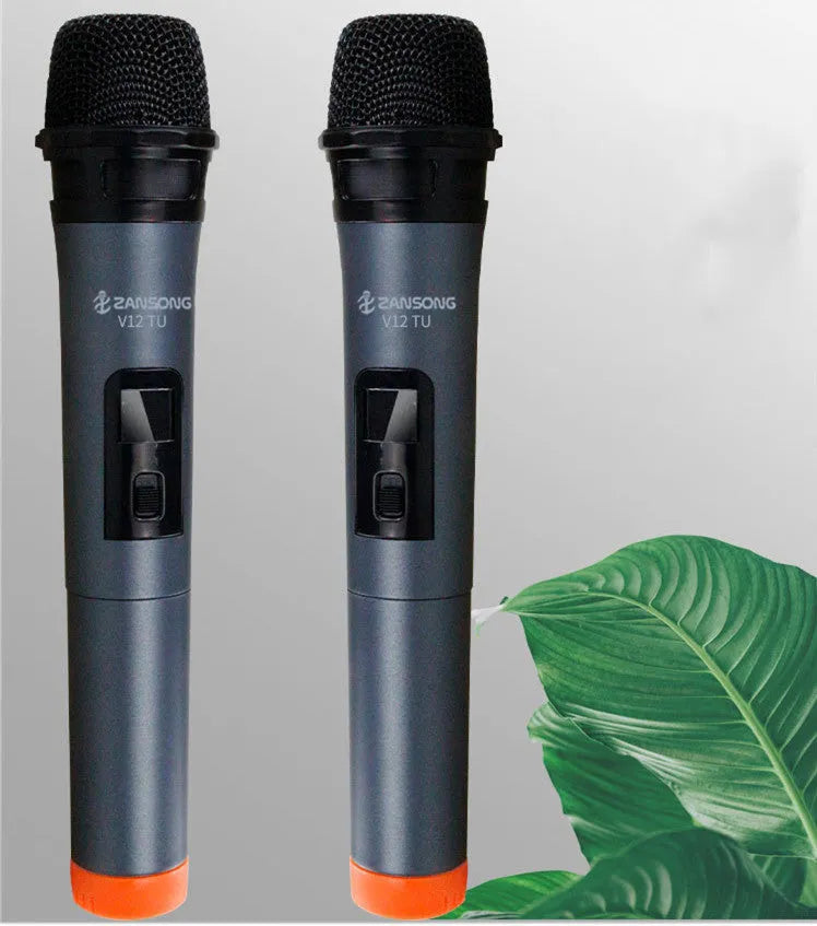 Black handheld dynamic microphone with USB receiver and cables on a table.