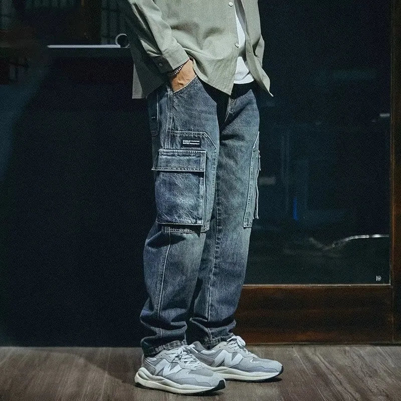 Men's loose straight-leg blue stretch denim jeans with a zip fly, shown on a hanger.