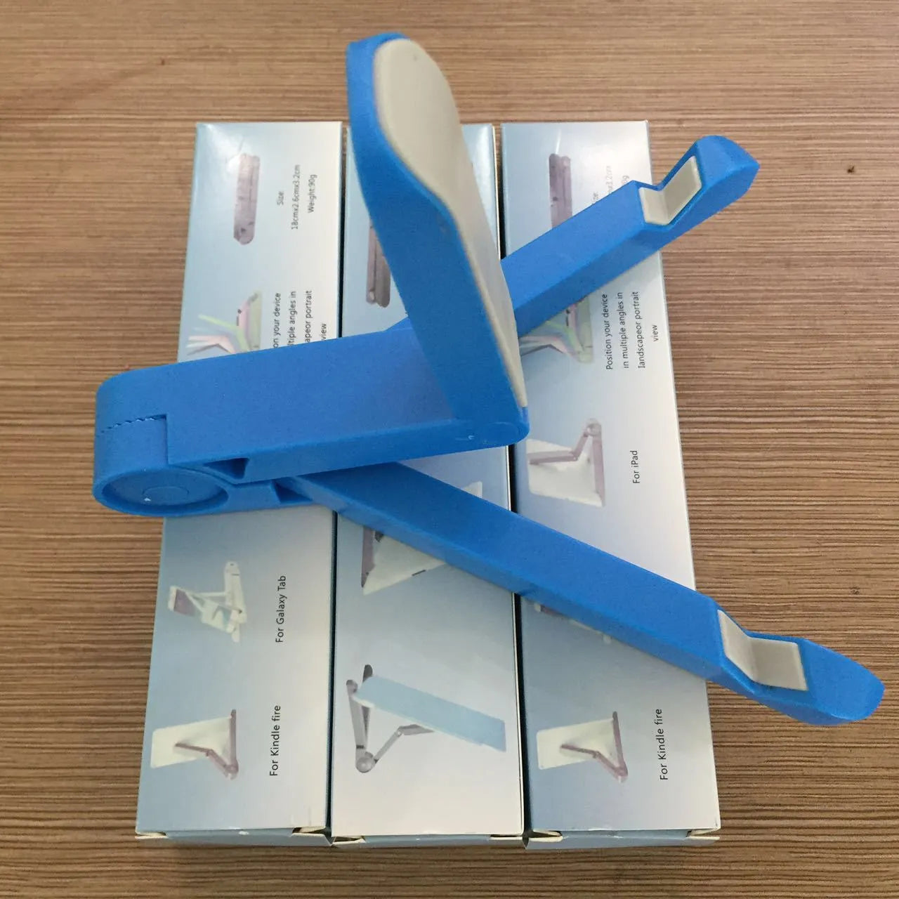 Black foldable tablet holder displaying smartphone in landscape position on desk