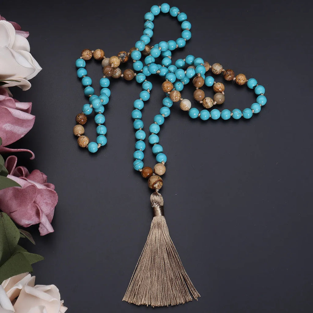 Handmade blue pine turquoise stone mala necklace with ball beads on a white background.