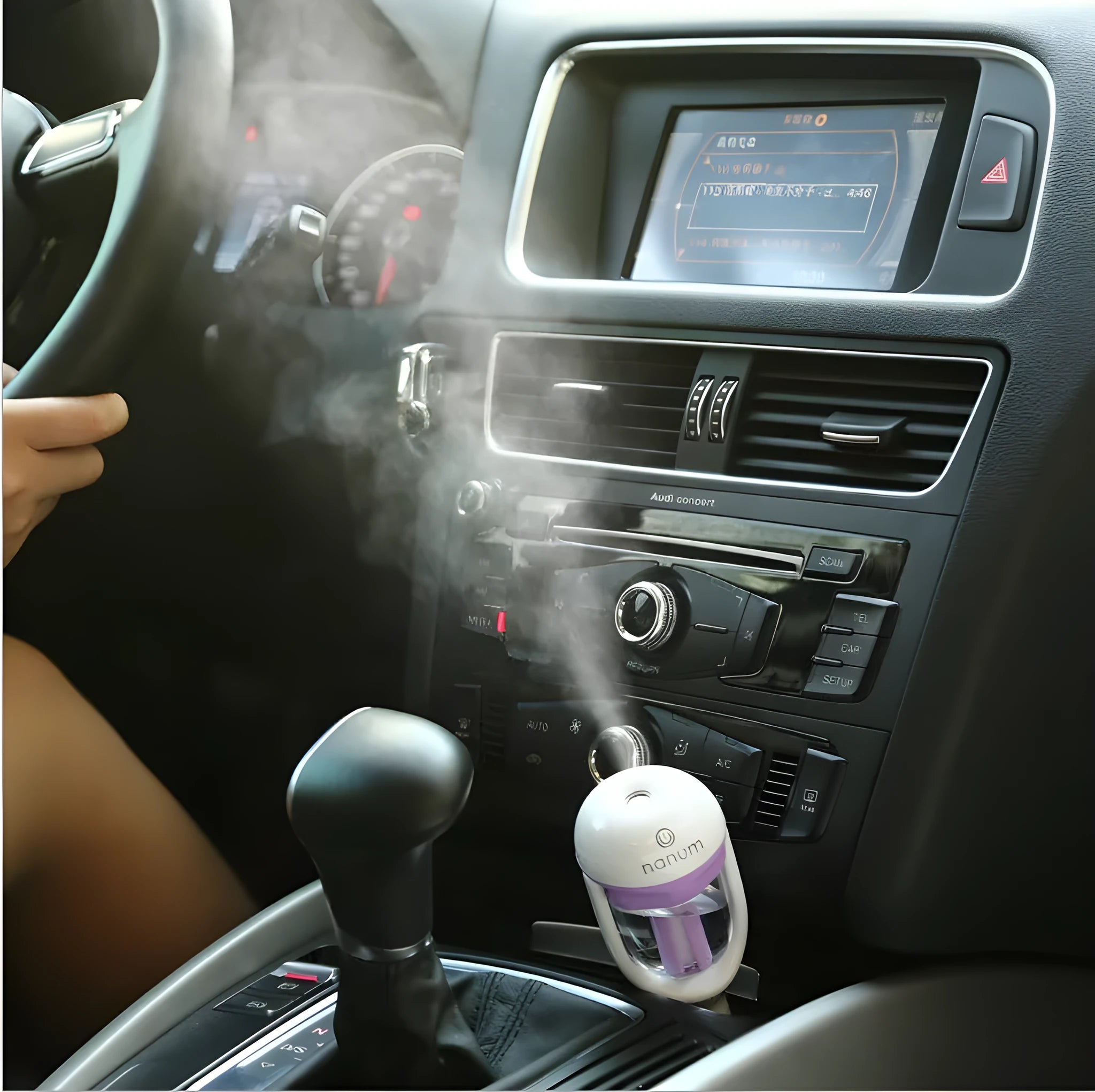 Compact blue portable car humidifier with essential oil diffuser on a car dashboard.