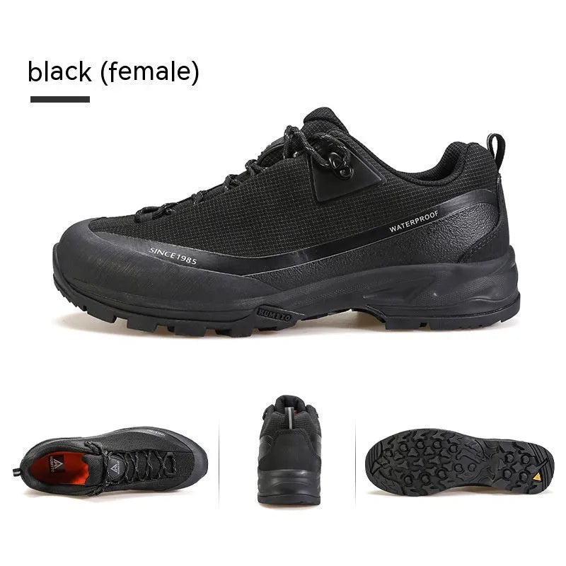 Men's low-top hiking boots in black with leather mesh upper and rubber outsole on a rocky path.