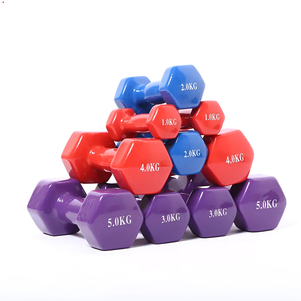 Set of bright coloured plastic fitness dumbbells in different weights on a floor.