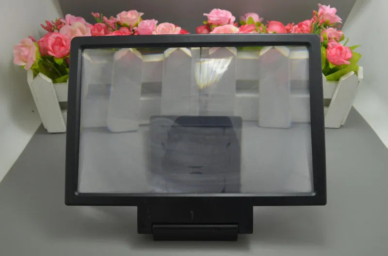 Black or white portable screen amplifier magnifier for mobile phones and laptops on a table.