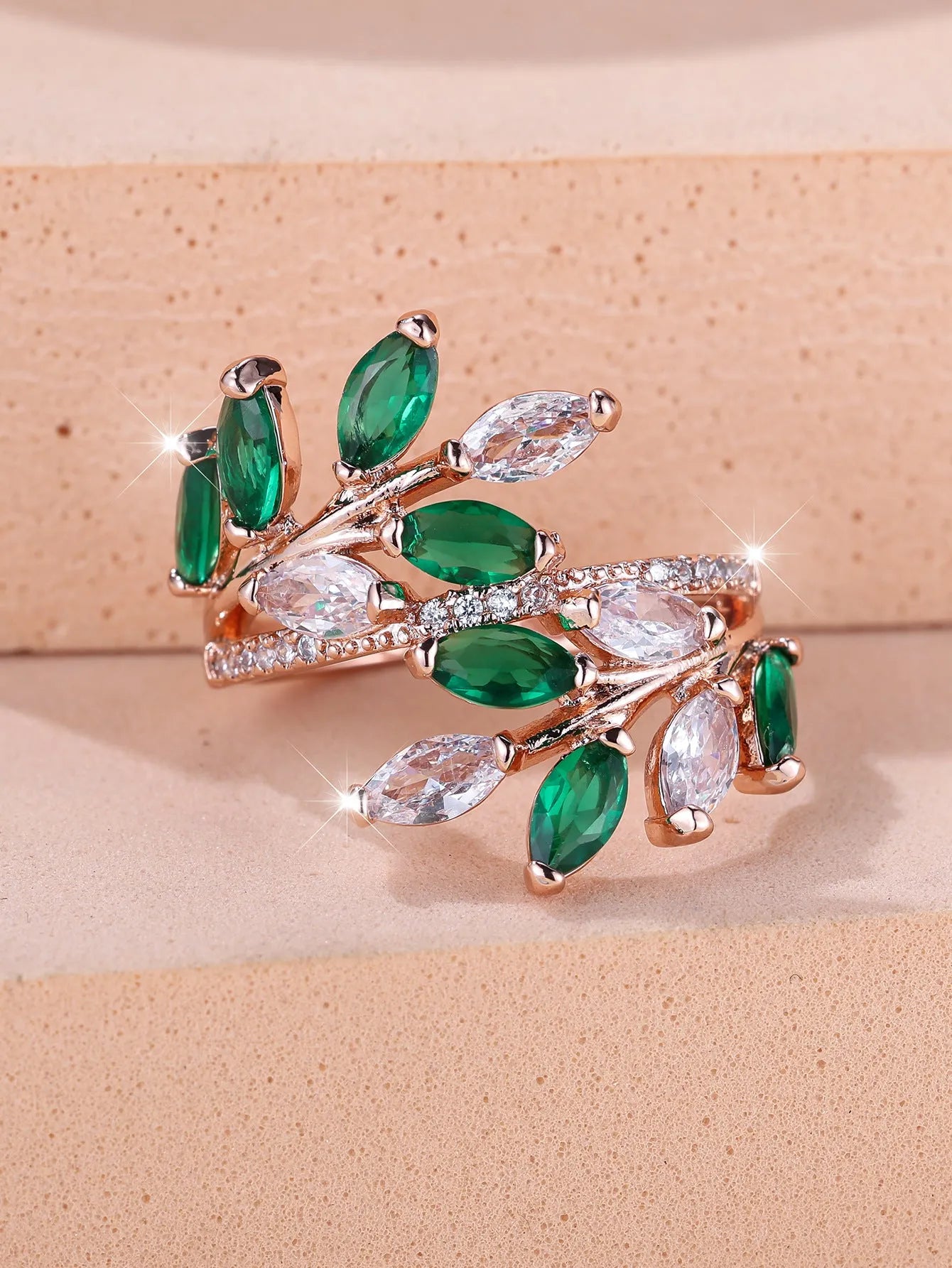 Adjustable copper leaf ring with a central zircon stone on a finger, showing rose gold and platinum colour options.
