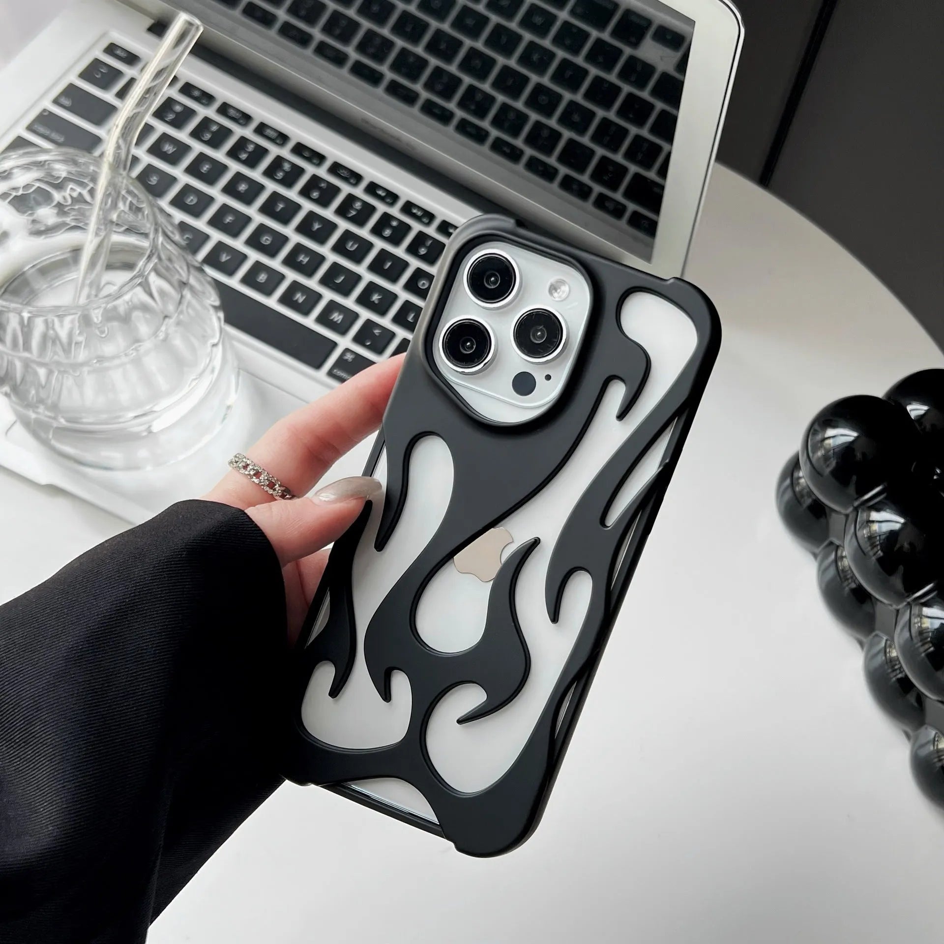 Silver electroplated iPhone case with hollow flame pattern design on a dark background