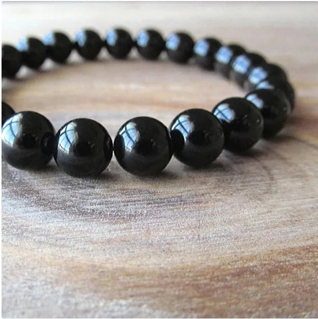 Geometric black onyx stretch bracelet with 8mm agate beads on an elastic cord.