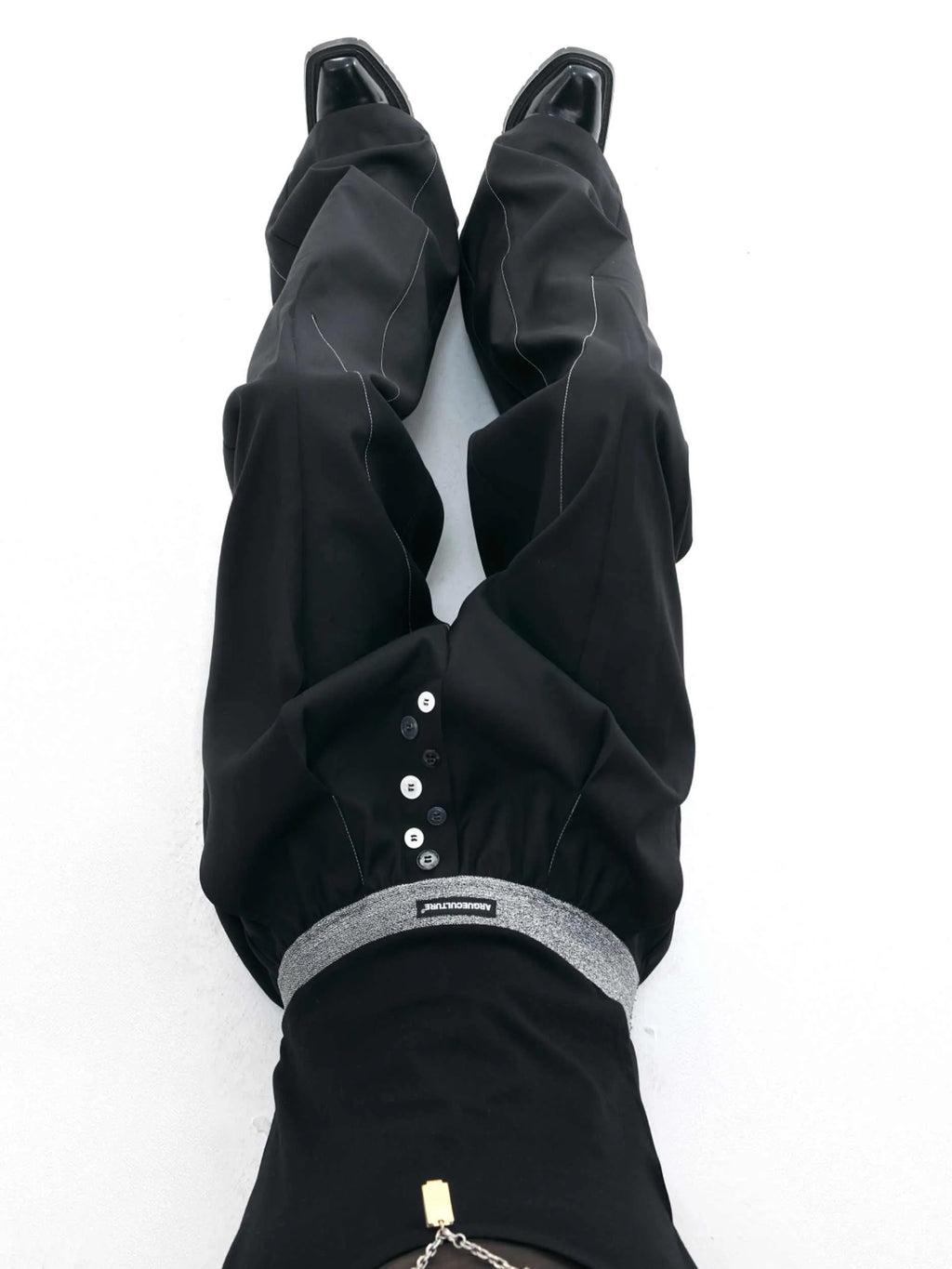 Straight-leg high-waisted casual trousers with a button-open front seam detail in black.