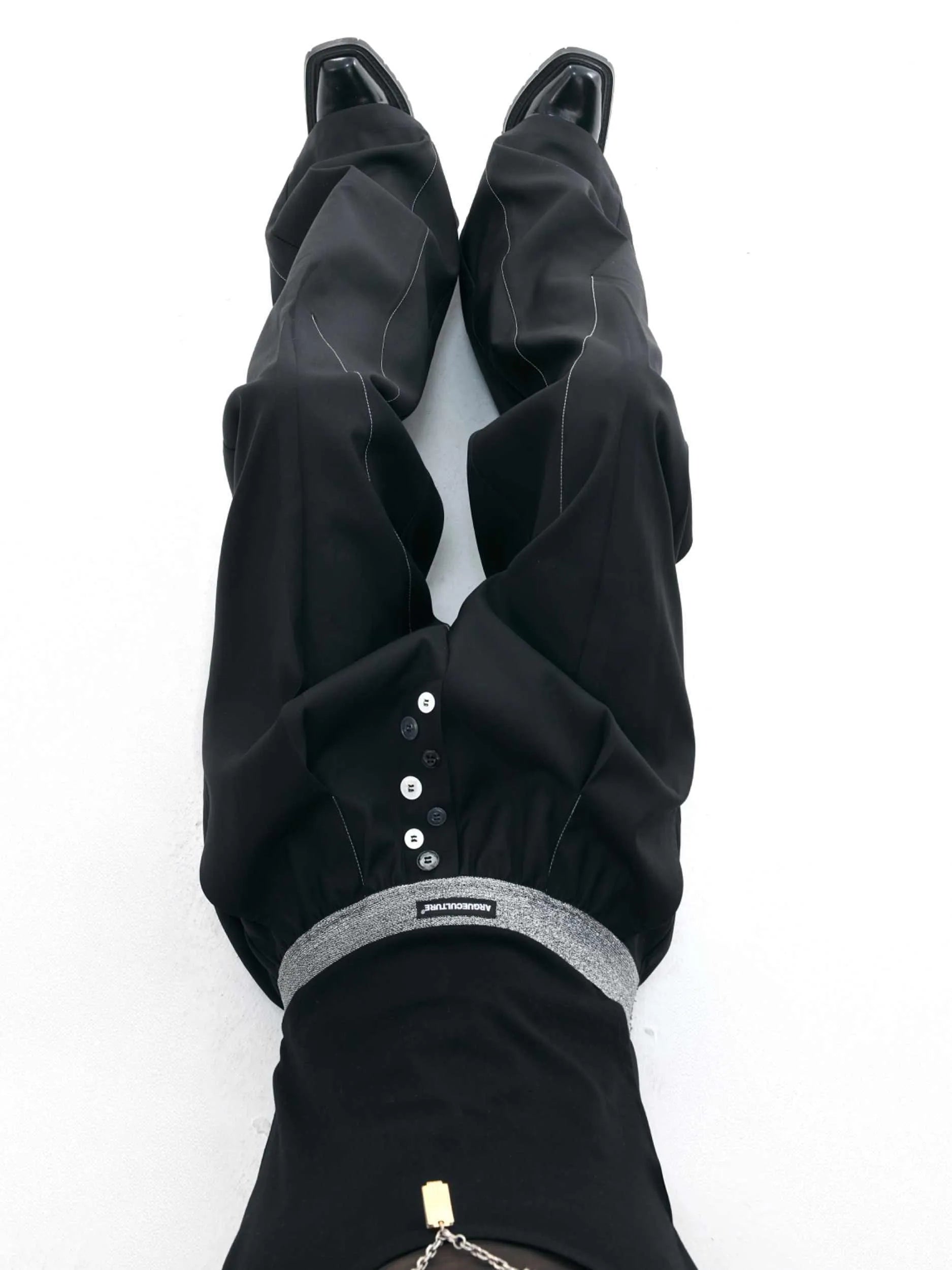 Straight-leg high-waisted casual trousers with a button-open front seam detail in black.