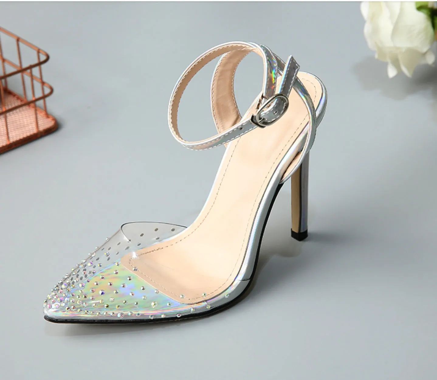 Women's pointed-toe sandals with glossy PVC upper and a thin stiletto heel on a neutral background.