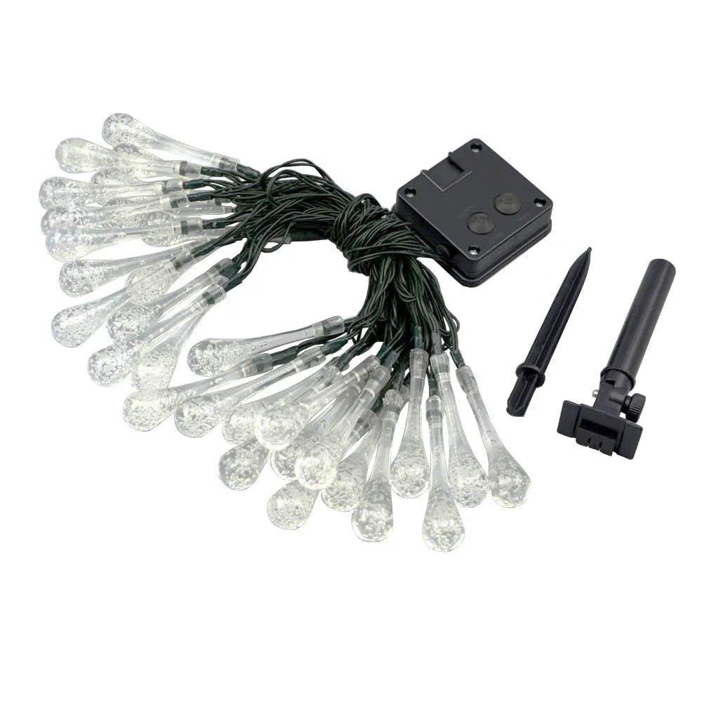 Solar-powered waterproof LED string lights with bubble drop pendants illuminating an outdoor garden space at dusk.