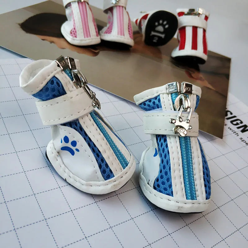 Four pairs of blue, pink, and red cloth dog shoes with zip fastenings on a white background.