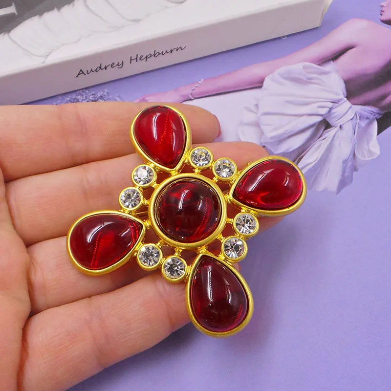 Close-up of a vintage medieval baroque cross brooch in zinc alloy with crystal accents, showing intricate detail.