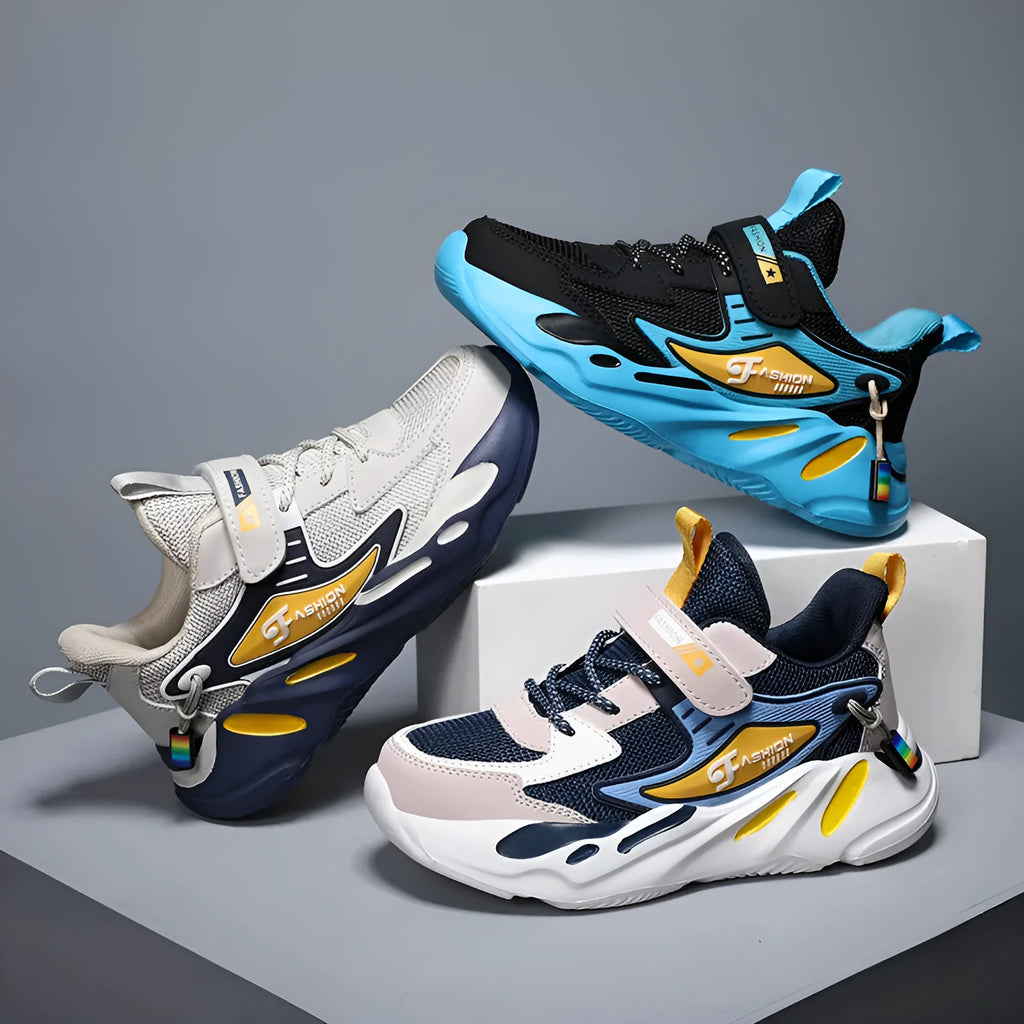 Boy's blue sports running shoe with velcro strap and mesh upper on a hard ground surface.
