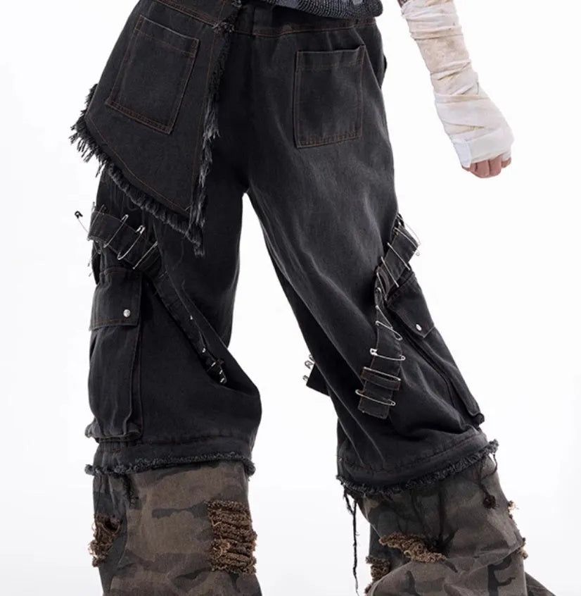 Men's grey jeans with camouflage splicing design and pin and ribbon details on the legs.