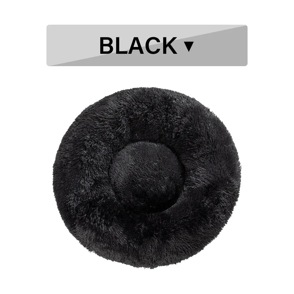 Fluffy grey donut-shaped dog bed with high plush sides on a wooden floor.