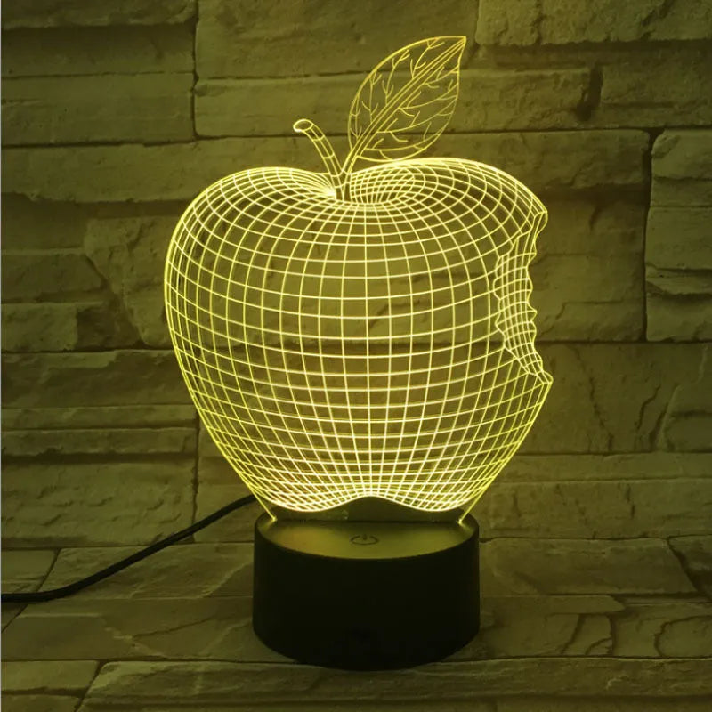 3D fruit-shaped colourful acrylic night light with touch control on a dark surface.