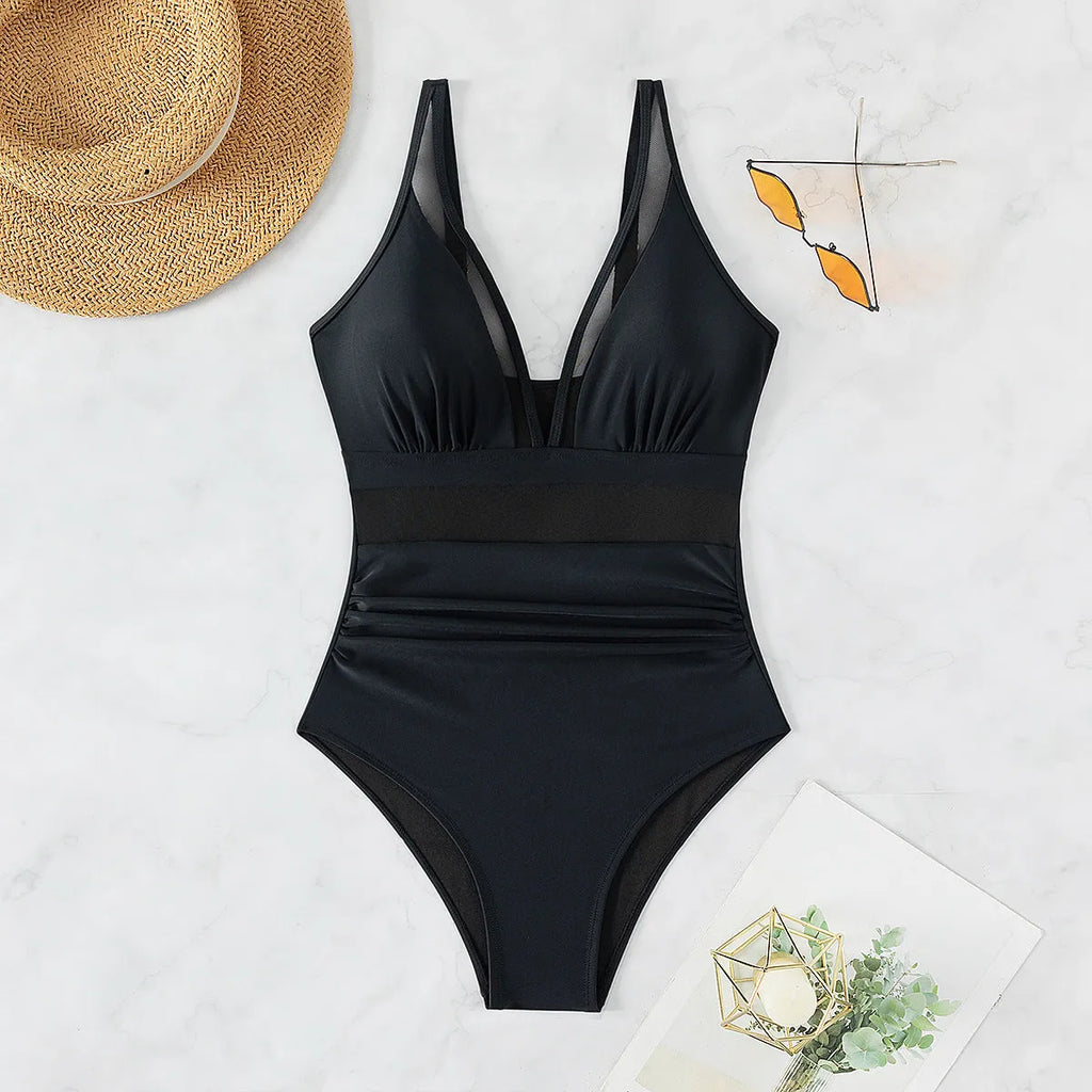 Black halter neck one-piece swimsuit with bikini style briefs, made from nylon fabric.