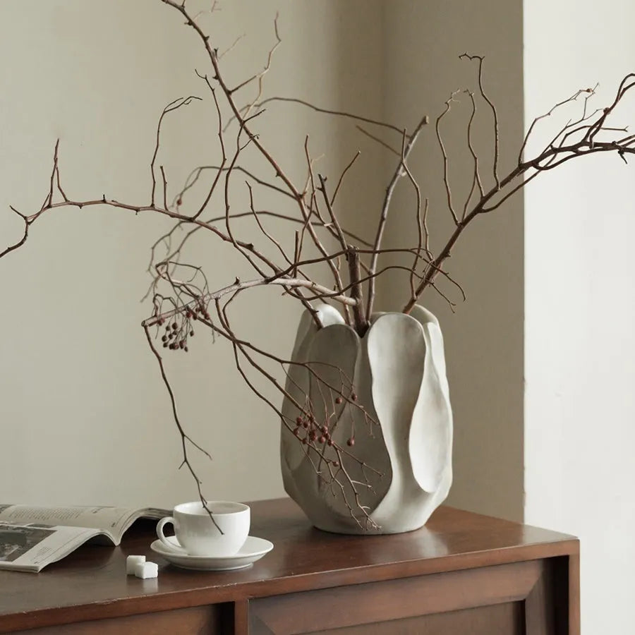 Irregular shaped ceramic art vase for flower arrangements on a desktop.