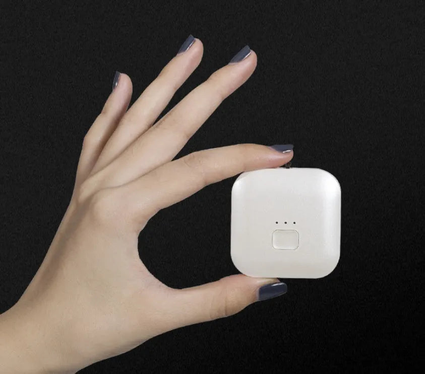 Pink portable USB air purifier necklace with charging cable showing compact wearable design