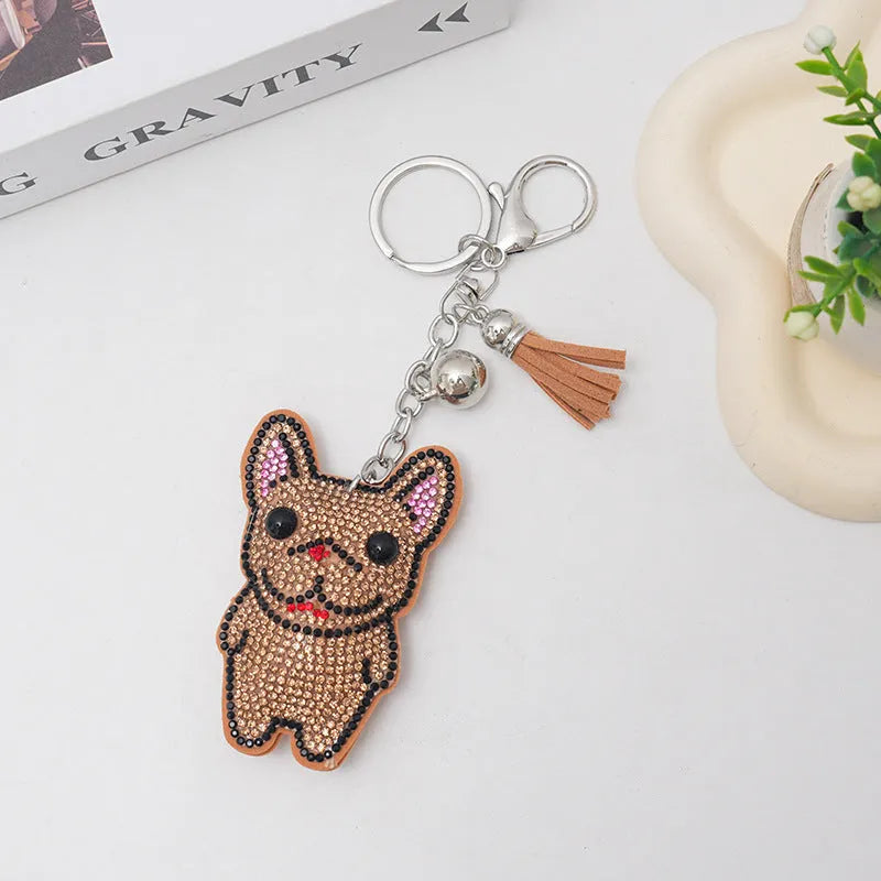 Close-up of a caramel-coloured alloy dog keychain with sparkling clear rhinestones.