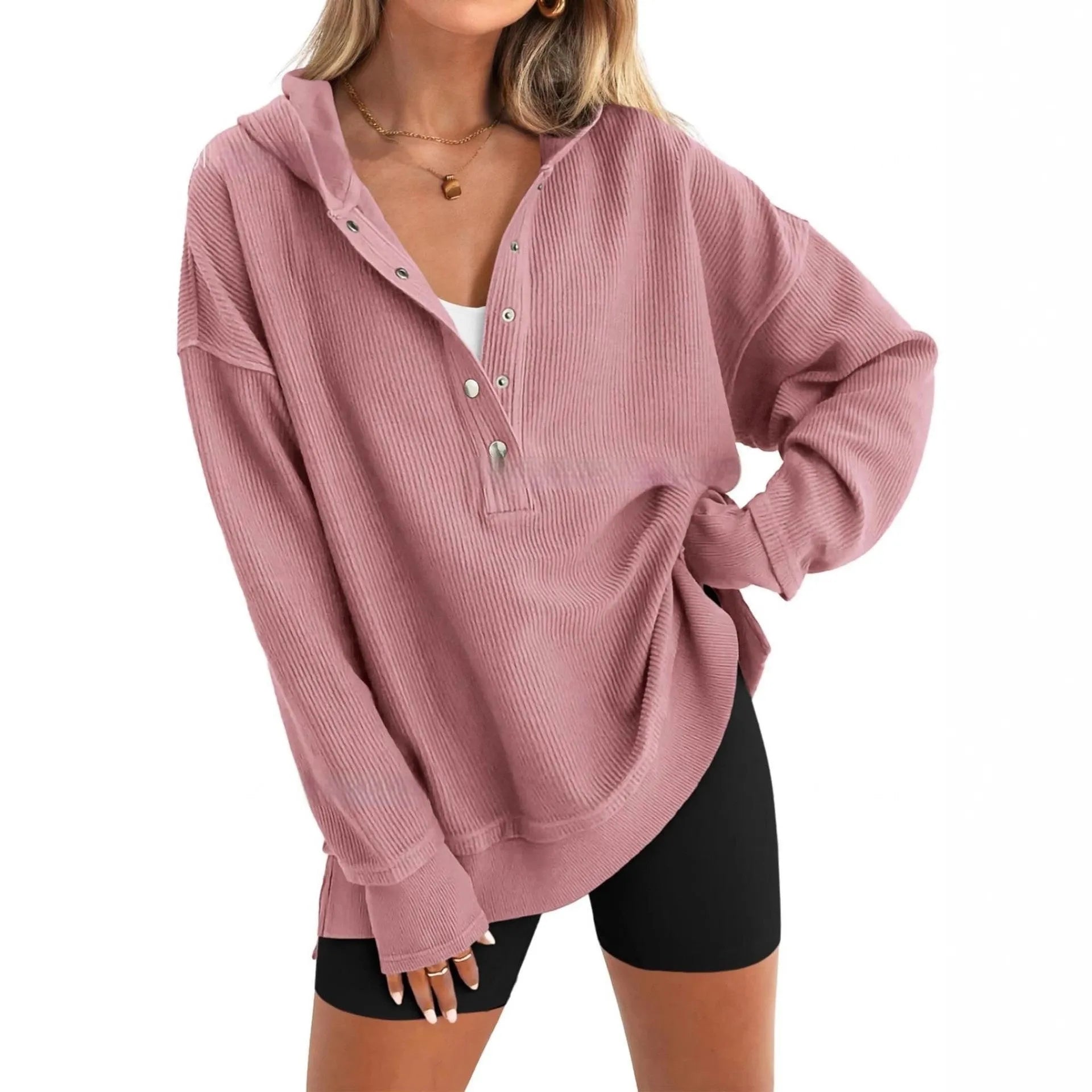 A woman wearing a loose peacock green pullover sweater with raglan sleeves.