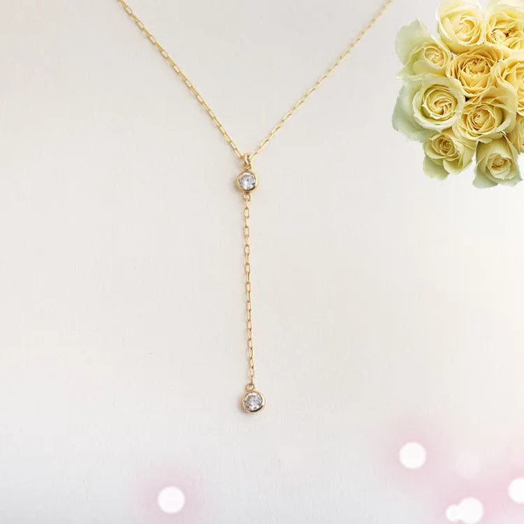 Gold alloy snake bone chain necklace with geometric pendant on display