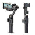 Black handheld smartphone gimbal stabilizer on a table