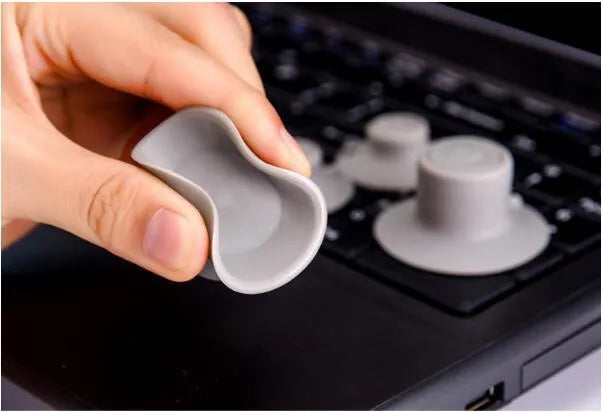 Four grey durable plastic laptop cooling pads, two large and two small, placed on a desk surface.