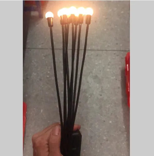 Solar-powered LED firefly garden spike light with multiple heads and a press-in ground plug on grass.
