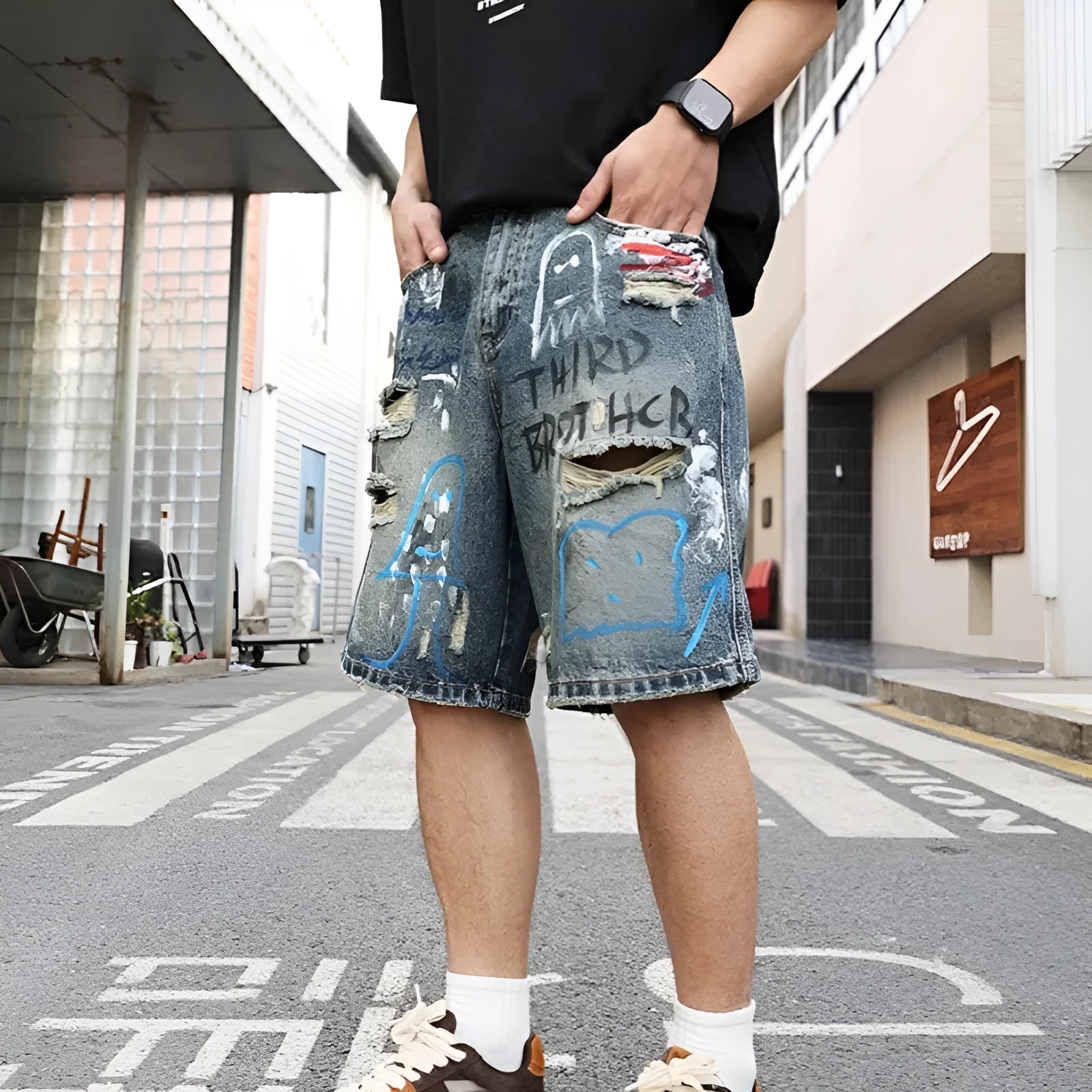 Men's blue ripped jeans shorts with straight leg cut, zipper fly, and graffiti detailing