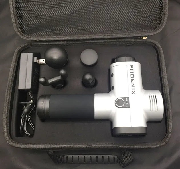 A black or silver ABS plastic percussion massage gun with four different removable massage heads on a table.