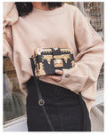 Women's black structured PU leather flap shoulder bag with cross-body strap and rivet details.