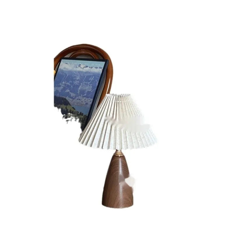 Nordic retro style ceramic table lamp with a tapered floral pleated shade and remote control on a wooden surface.