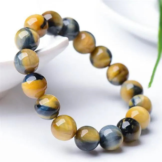 Fantasy tigereye agate bracelet with round beads on a wrist, showing natural stone patterns.