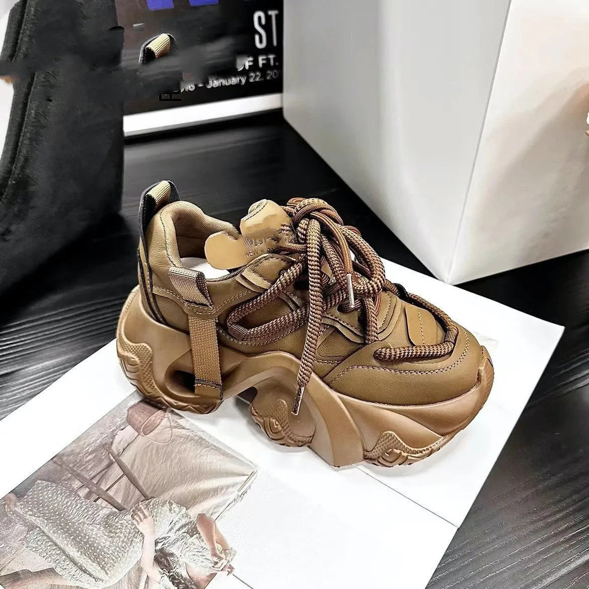 Women's creamy white platform sneakers with cross straps and a wedge heel on a casual background.
