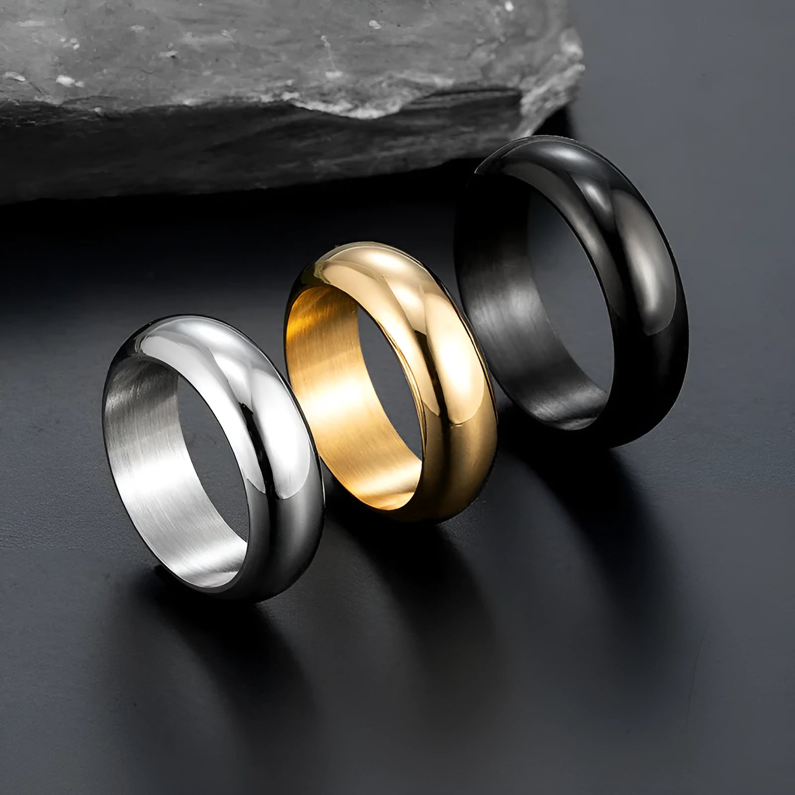 Glossy electroplated titanium steel ring in gold, black and steel colours showing metallic finish