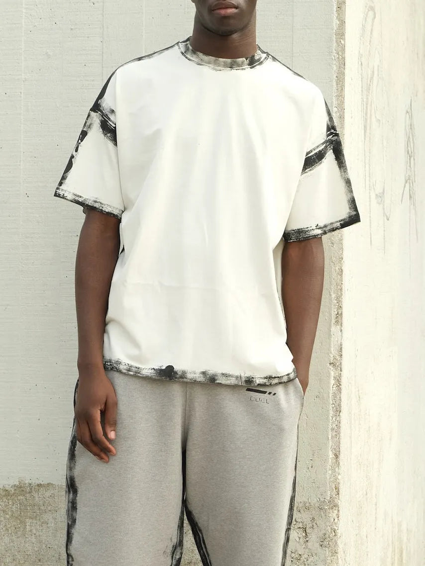 White casual short sleeve top with a draped design and printed pattern.