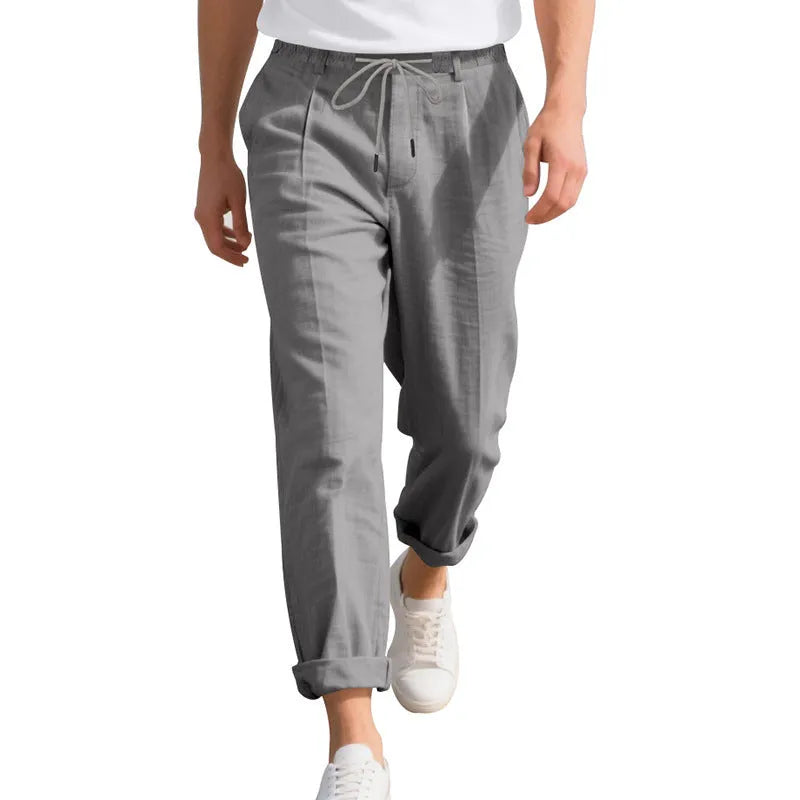 Man wearing light khaki linen casual trousers with a drawstring waist and straight-leg fit.