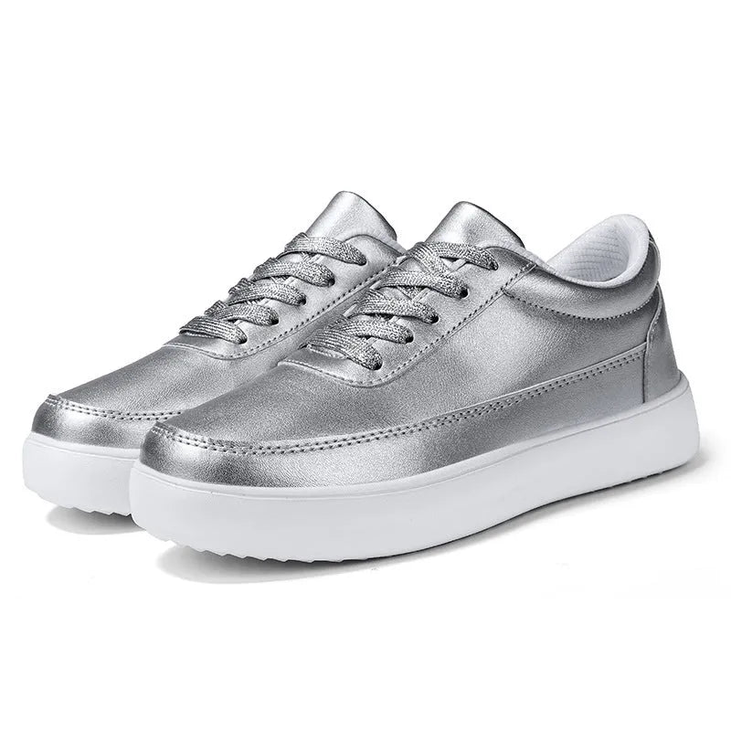 Women's gold leather lace-up flat casual shoes on a white background.