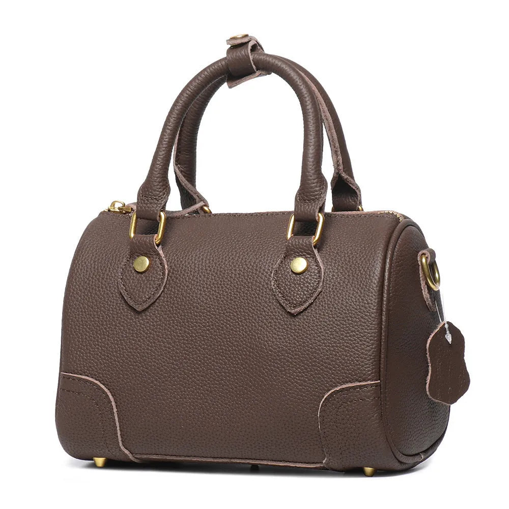 Brown yellow cowhide leather Boston bag with single shoulder strap, showing cylindrical shape and open outer pocket.