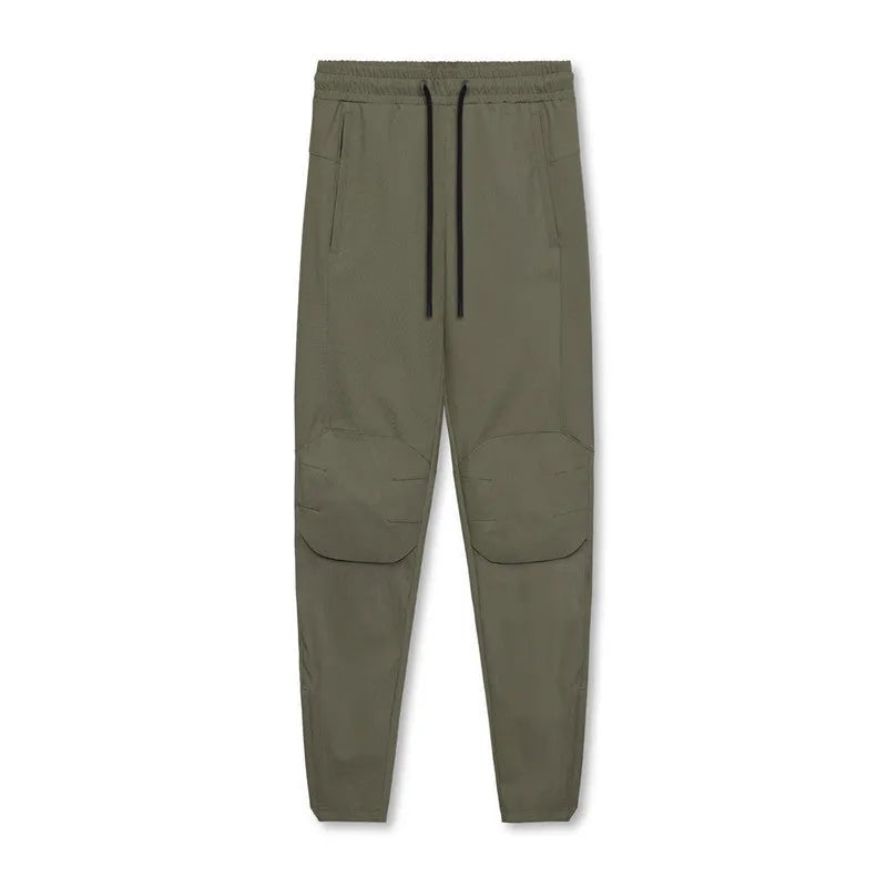 Men's loose-fit grey fitness trousers with an ankle-tied cuff, made from quick-dry polyester, laid flat.