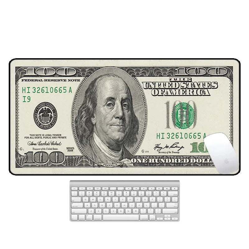 Large printed desk mouse pad with natural rubber non-slip base, shown on a wooden desk.