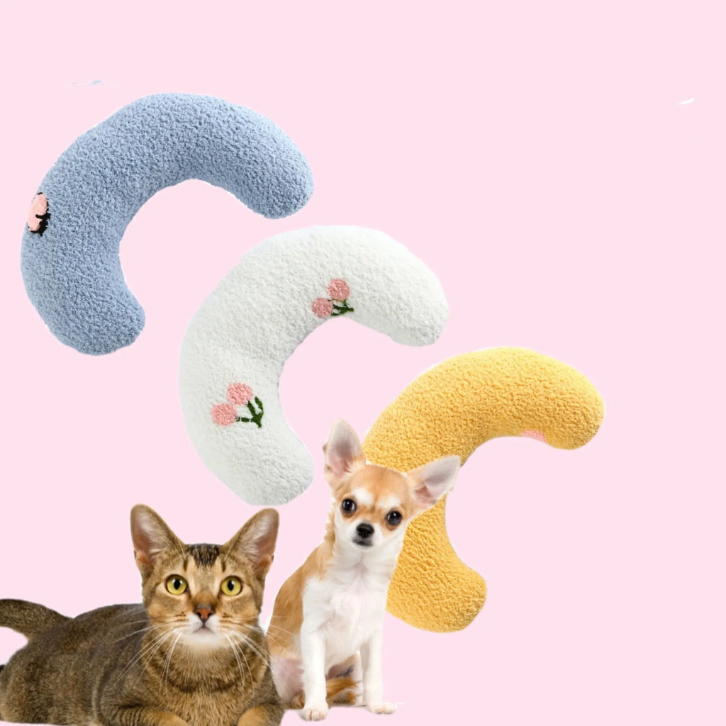 White U-shaped plush pet pillow for a small cat or dog on a grey background.