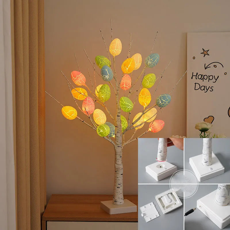 White plastic birch tree Easter decoration with warm white LED lights and hanging coloured eggs on adjustable branches.