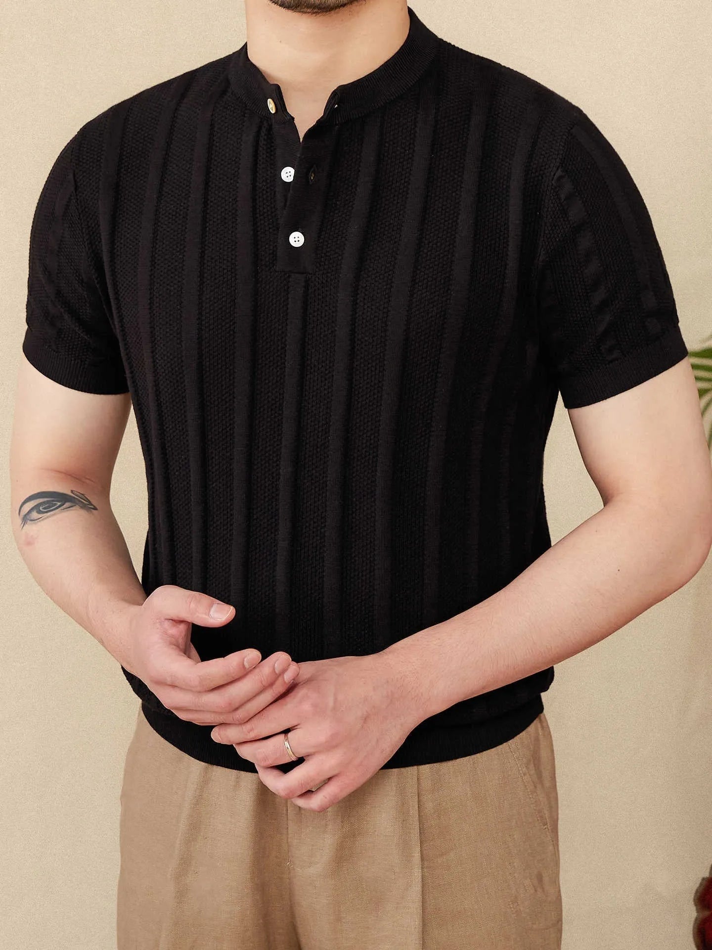 Men's creamy-white knitted short-sleeve t-shirt with a Henry collar and sunken stripe texture.