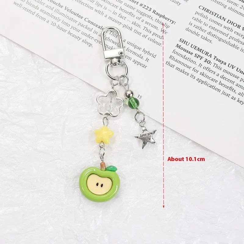 Fruit-themed mobile phone charm keychain with apple and strawberry designs in plastic/resin construction