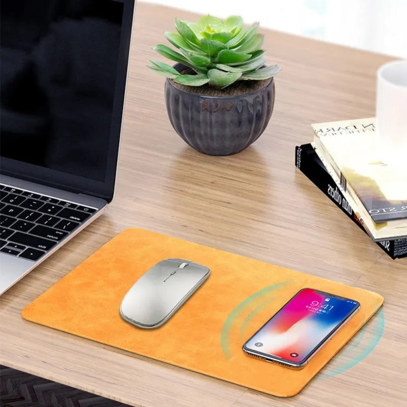 Brown PU leather wireless charging mouse pad with micro-USB cable on a wooden desk.