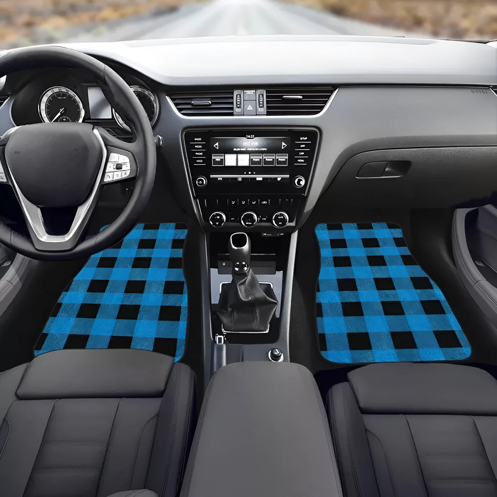 Set of four black rubber car floor mats with a textured surface and raised edges, shown in a vehicle footwell.